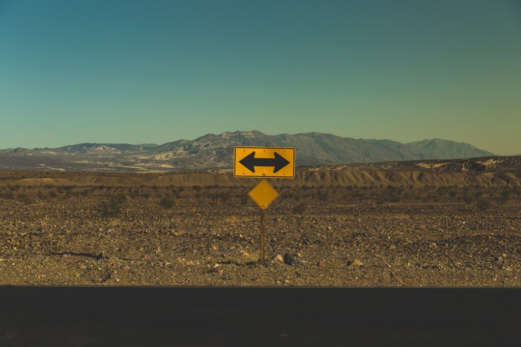 road sign indicating directions in a barren landscape