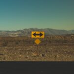 road sign indicating directions in a barren landscape