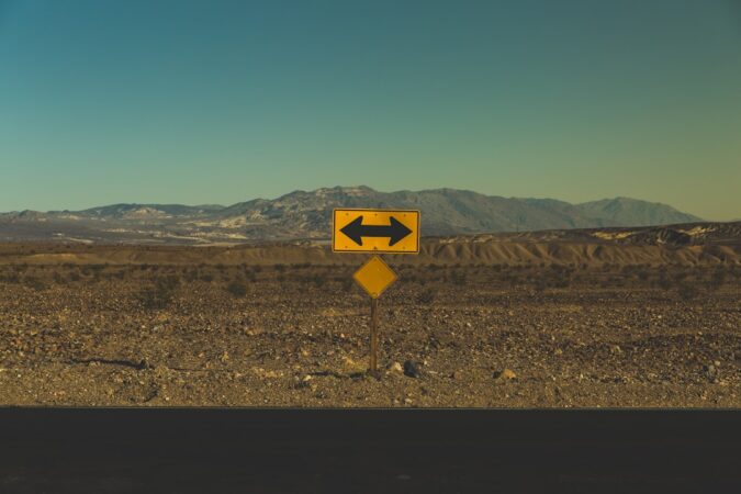 road sign indicating directions in a barren landscape