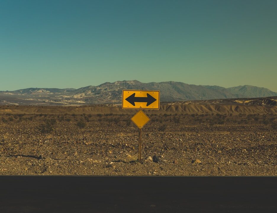 road sign indicating directions in a barren landscape