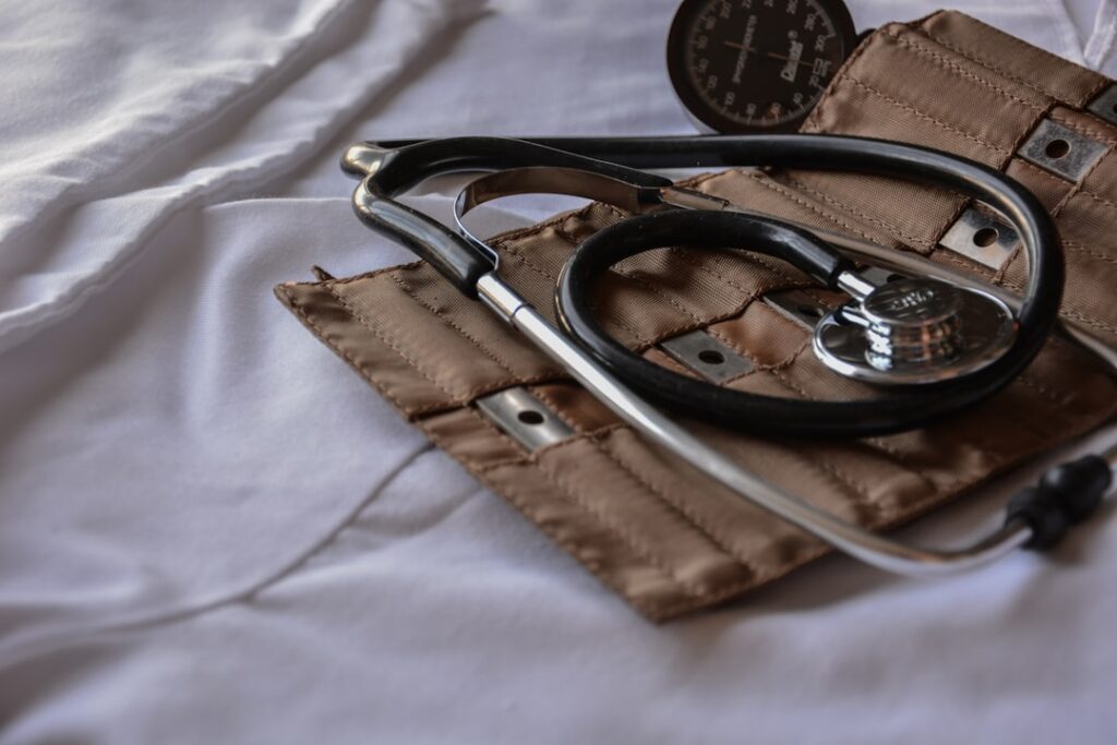 A stethoscope and blood pressure cuff on a white surface, symbolizing healthcare equipment.