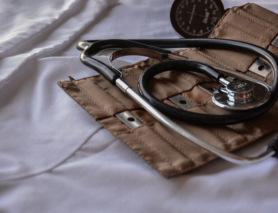 A stethoscope and blood pressure cuff on a white surface, symbolizing healthcare equipment.