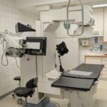 Medical imaging equipment in a clinical setting, featuring a treatment table and advanced imaging technology.